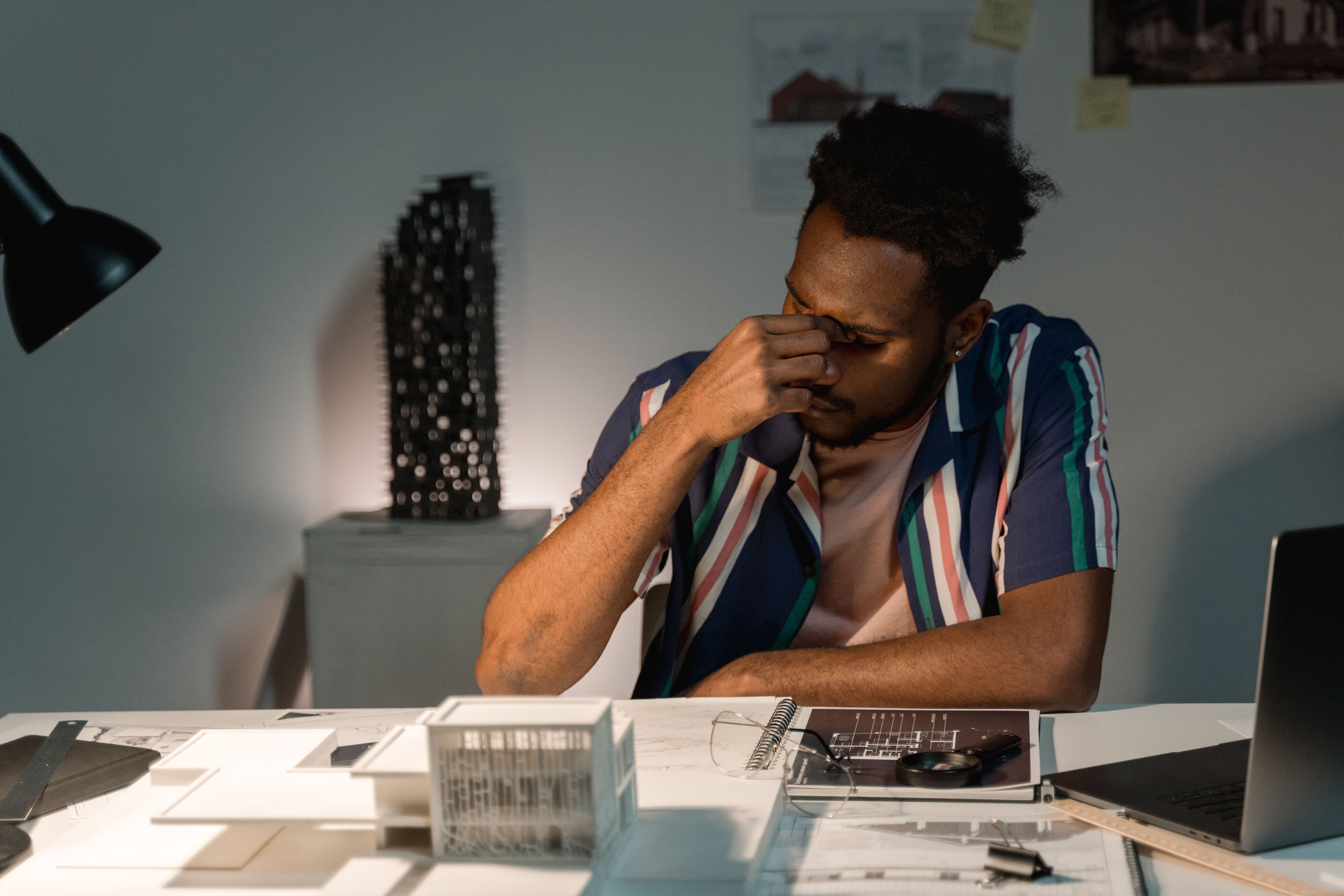 Exhausted creative working late over design plans.