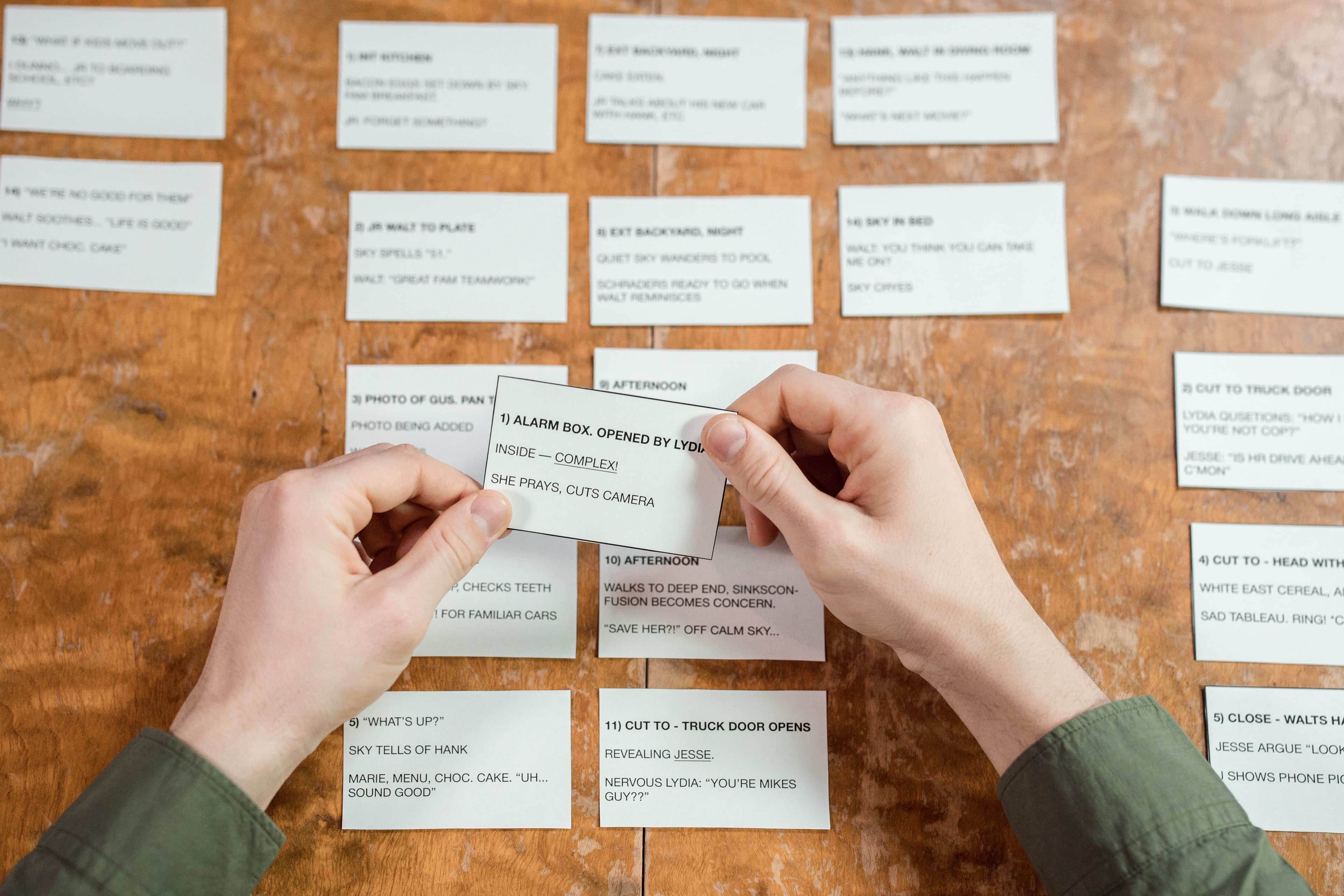 Hands organizing planning cards on a desk for a focused content idea.
