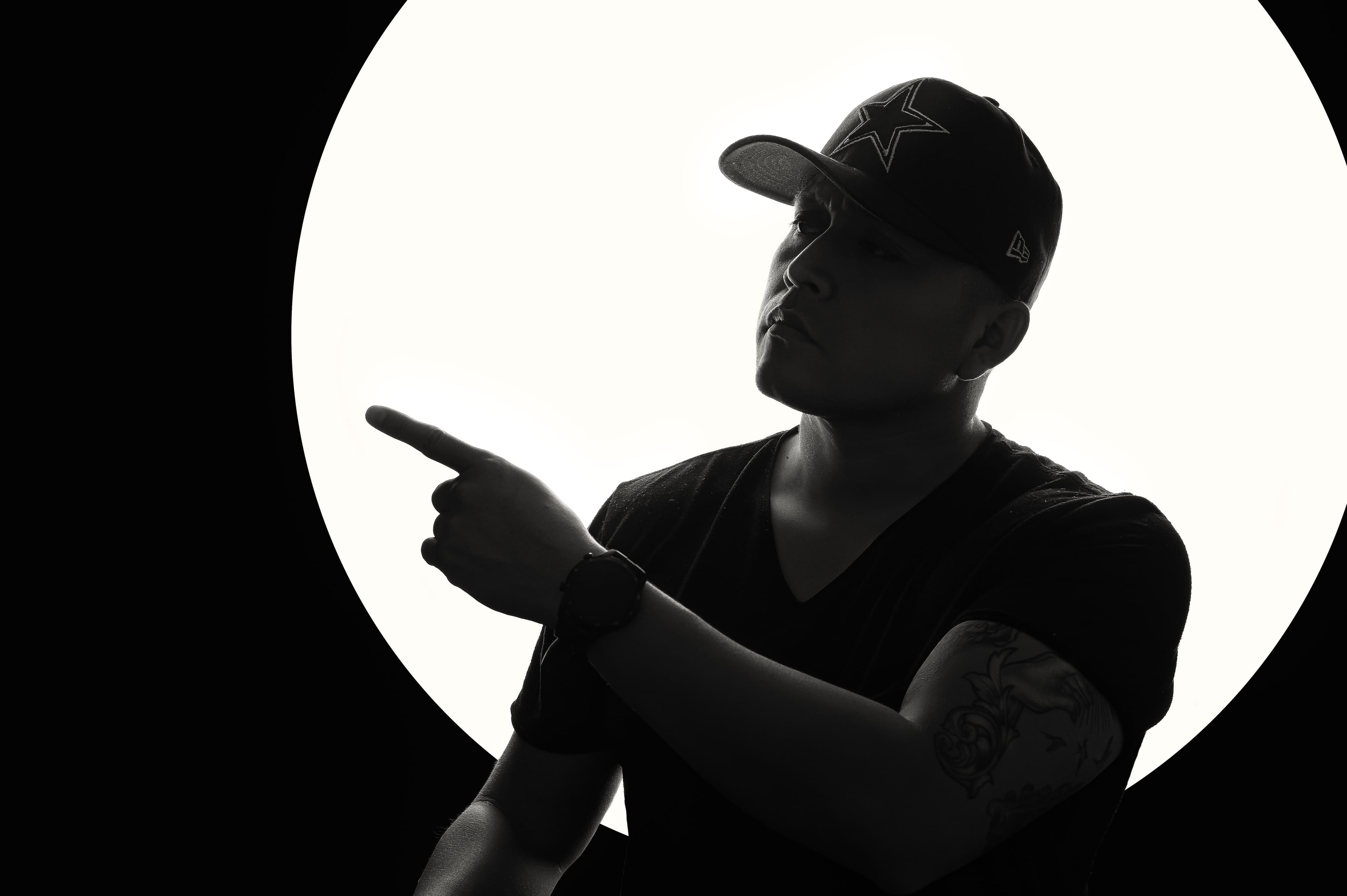 Studio portrait with a strong directional pose and high-contrast lighting.